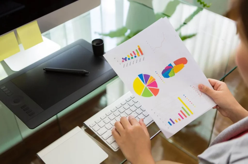 femme devant son bureau avec son ordinateur et des graphiques représentant l'analyse pareto