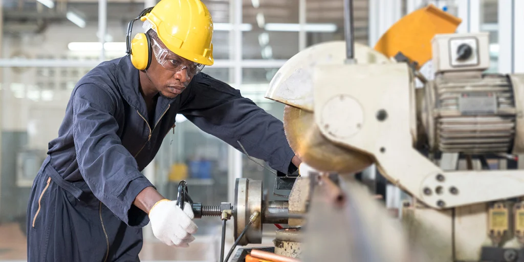 Une ingénieure en casque et gilet réfléchissant utilise un ordinateur portable, entourée de graphiques représentant des technologies et des équipements industriels, illustrant la méthode QQOCQCCP.